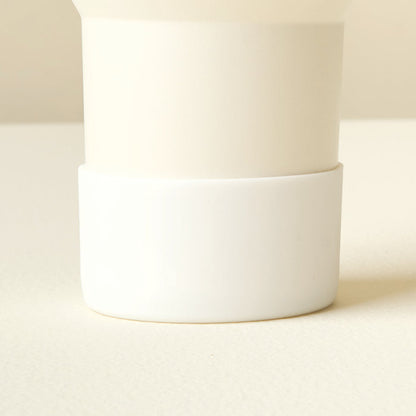 Close-up of The Darling Effect’s White Tumbler Silicone Boot on a pale cream tumbler, showing its no-slip protection and sleek two-toned design.