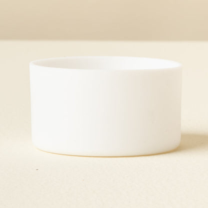 The Darling Effect White Tumbler Silicone Boot is shown on a light, cream surface with a neutral background, offering added protection for your tumbler.