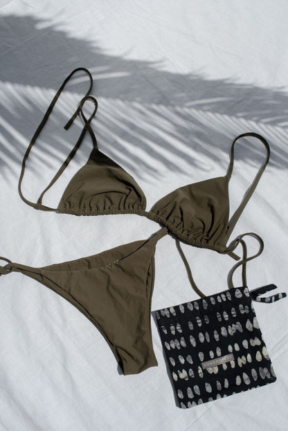 Brown bikini set with a black and white patterned bag on a light background