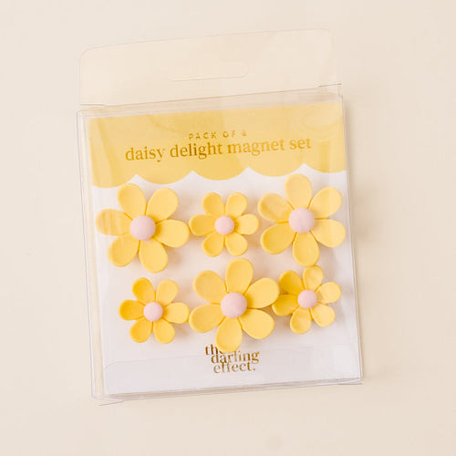 The Yellow Daisy Delight Magnet Set by the-darling-effect features six vibrant yellow daisy magnets with pink centers in a clear package. These magnets offer a strong hold, perfect for any surface.
