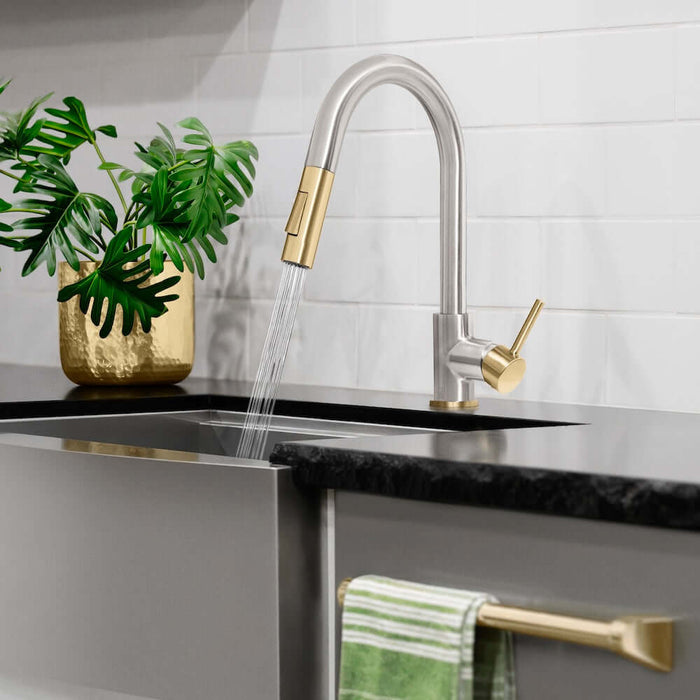 Modern kitchen sink with ZLINE Autograph Edition Gemini Pull Down Single Handle Kitchen Faucet in Brushed Nickel and Champagne Bronze (GEM-KF-ZBNCB) and running water, plant, and towel in the background.